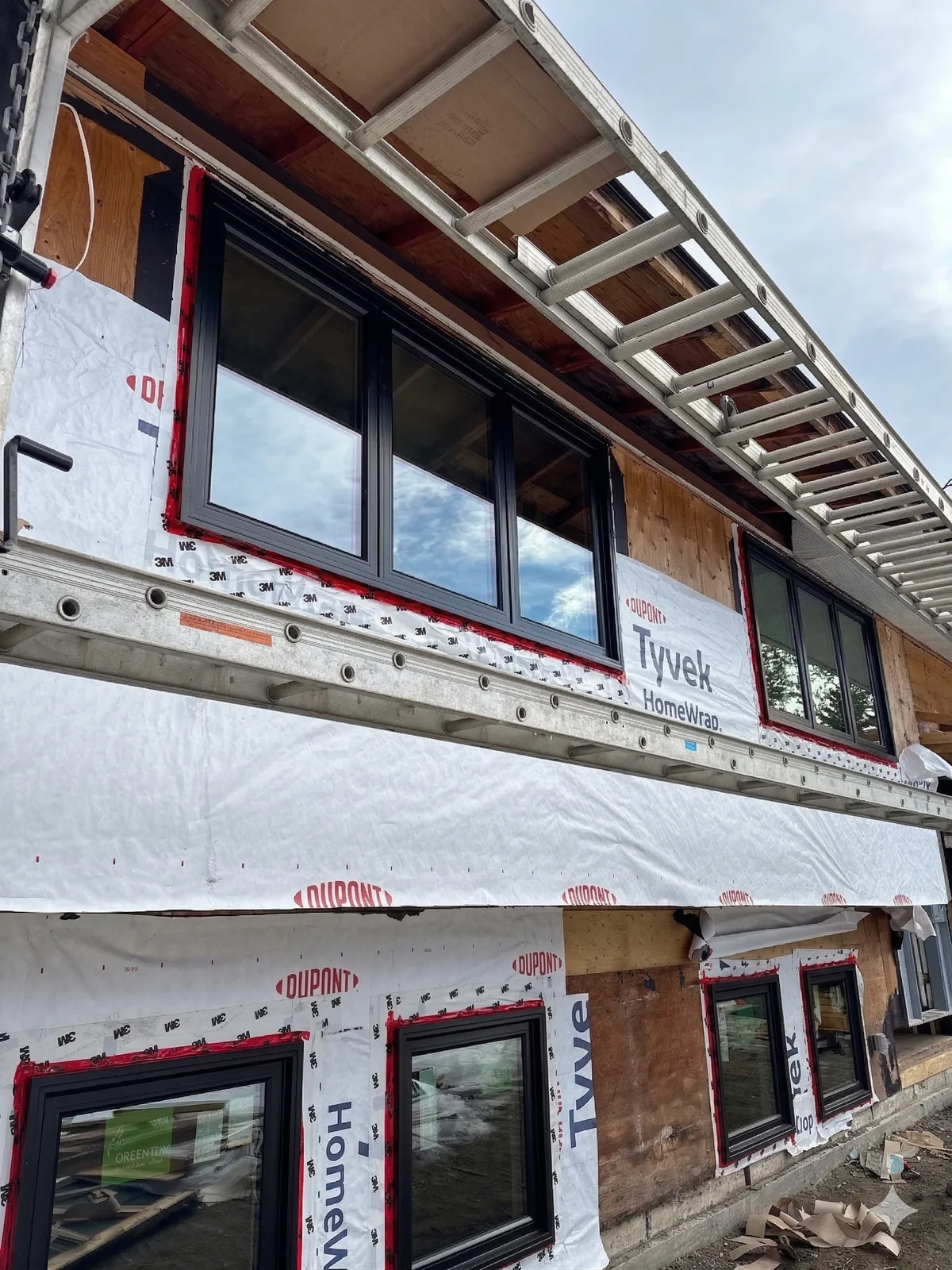 Blue skin waterproofing membrane applied around window opening during professional installation