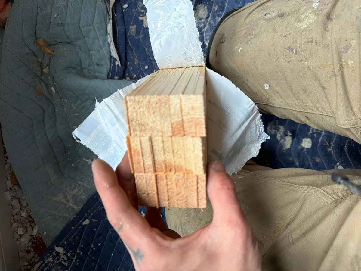 Measuring shim spacing with tape measure during window installation