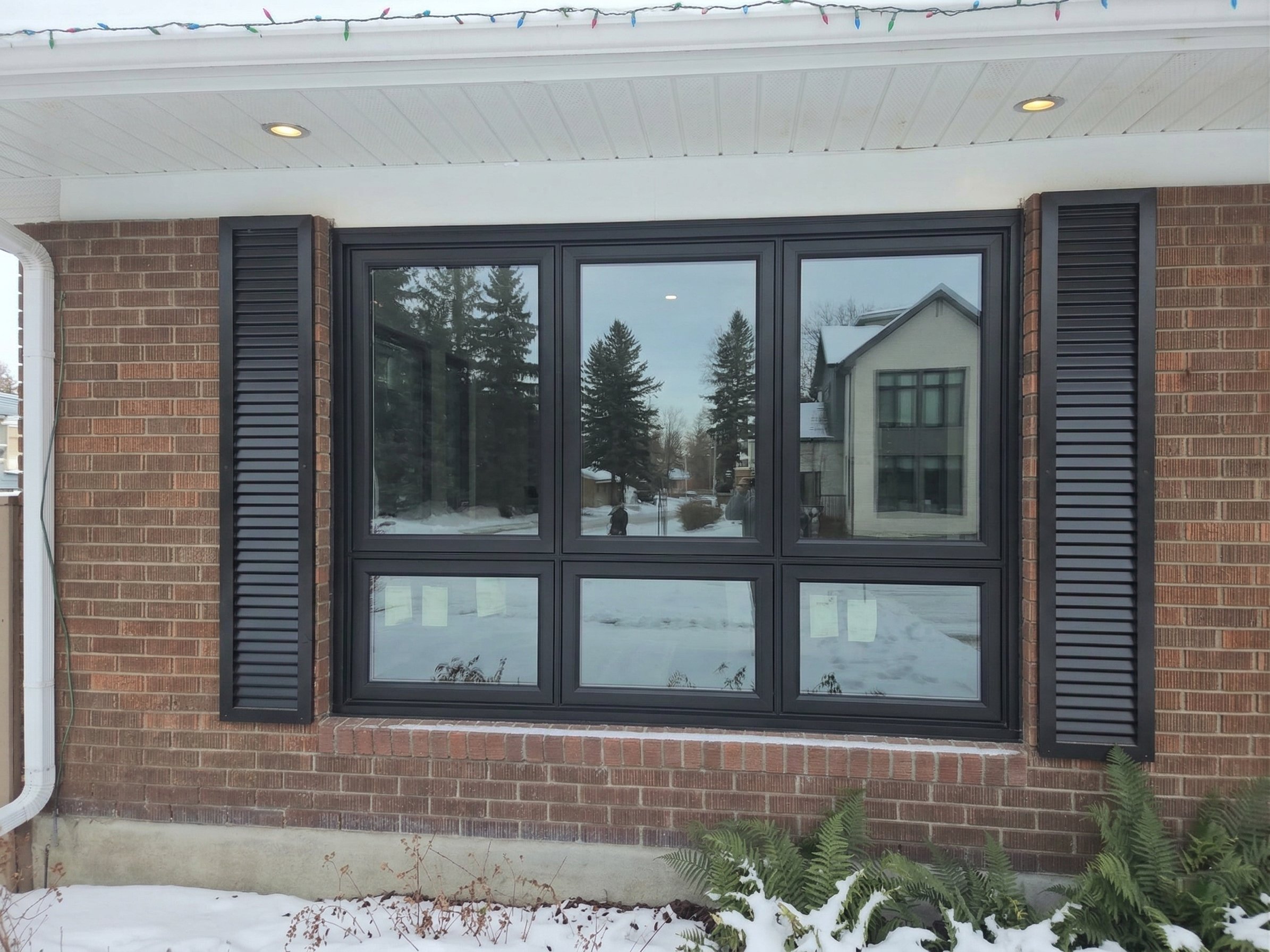 Brick home dark frame window upgrade in Calgary
